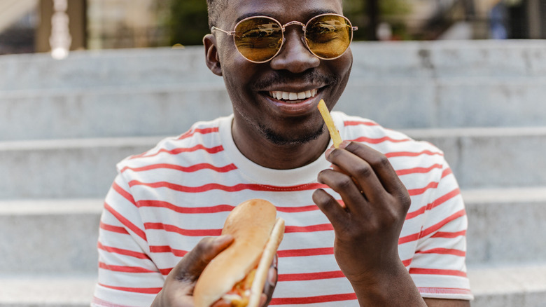 Man eating hot dog and french fry