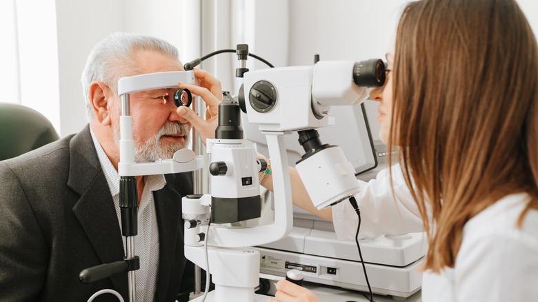 eye doctor examining older man's eyes
