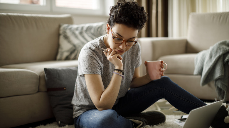 Young studious teen holding coffee mug
