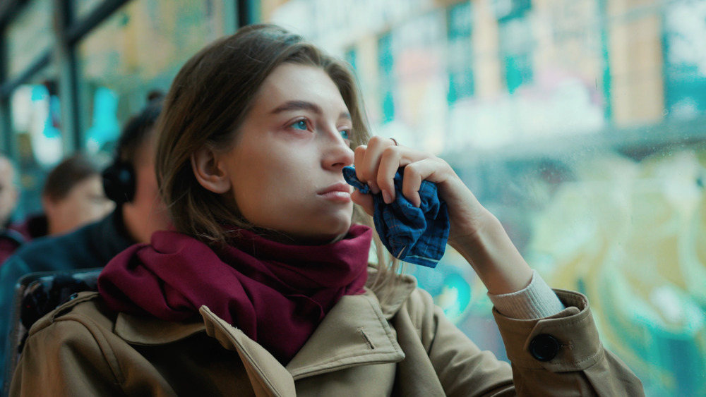 photo of a women on the bus holding a handkerchief at the start of flu season 