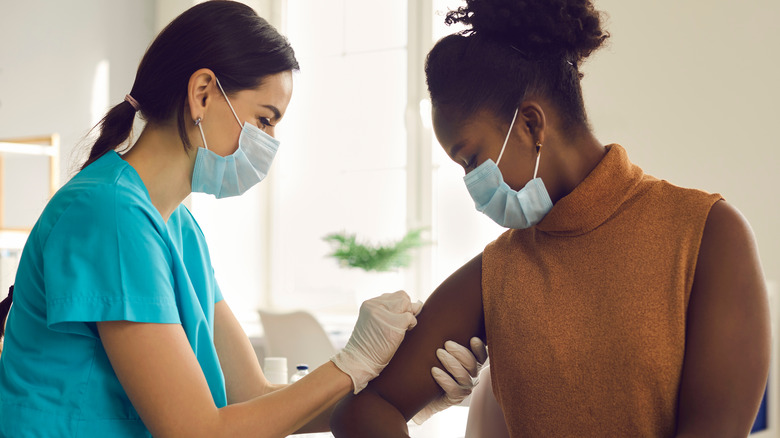 Masked woman receiving vaccine