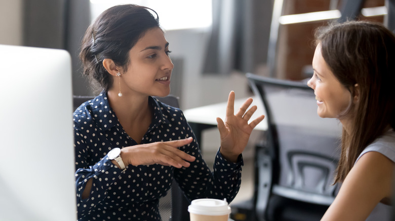 Two women talking and smiling over coffee