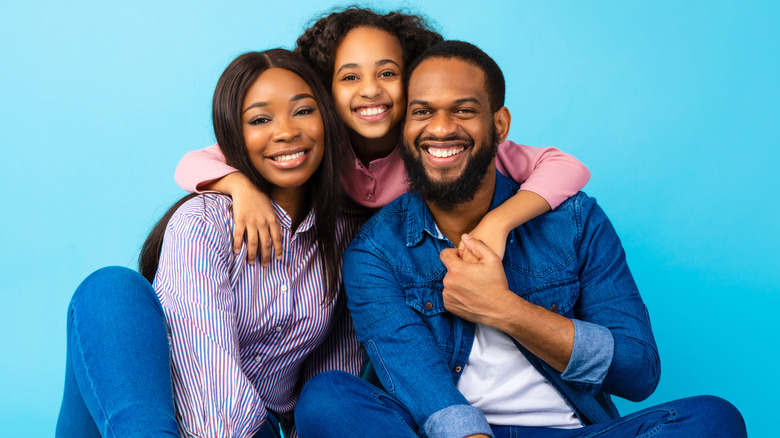 Father, mother, daughter hugging