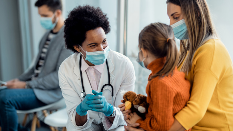 Masked patients talking to masked doctor