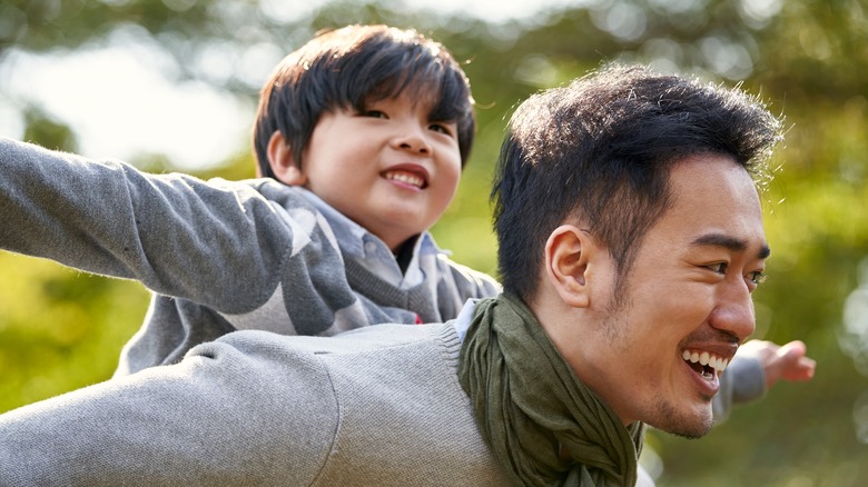 man and son playing in park