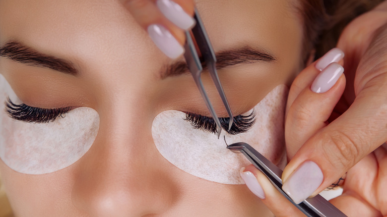 A closeup of a woman getting eyelash extensions