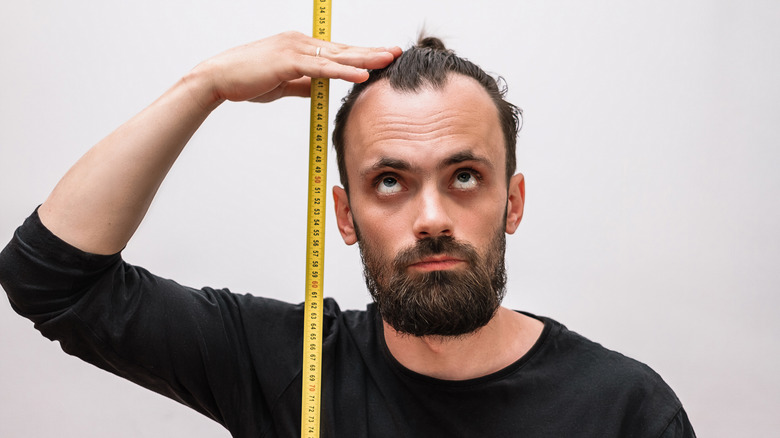 A man measures himself with a tape measure