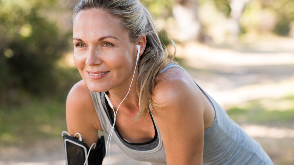 Older woman exercising with earbuds