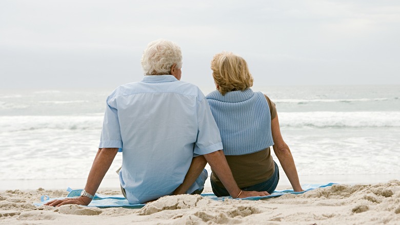 Elderly couple sitting on the beach