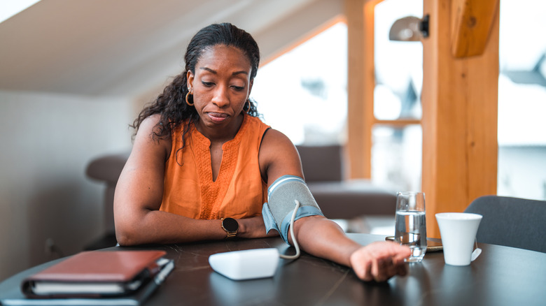 woman checking her blood pressure at home