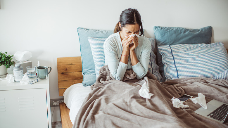 woman bed cold tissues nose