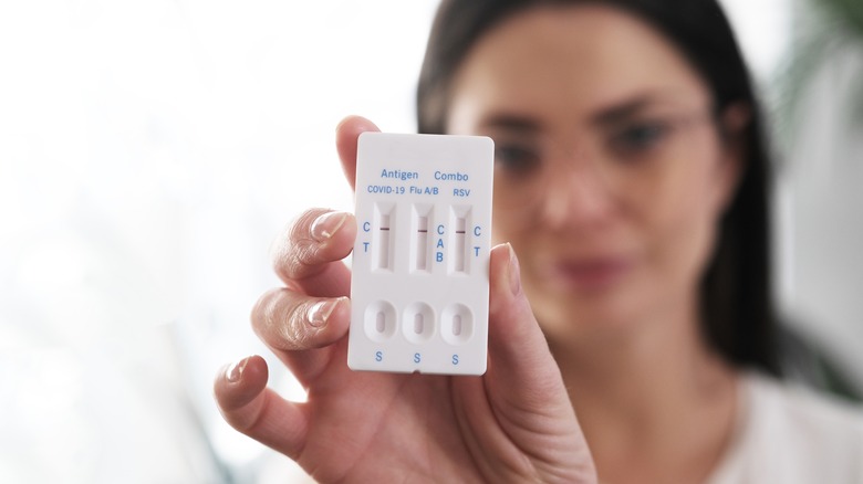 Woman holding combination antigen test