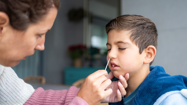 Mother swabbing child's nose