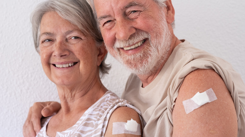 a woman shows off her second dose of bivalen booster