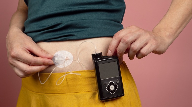 person with type 1 diabetes adjusting insulin pump