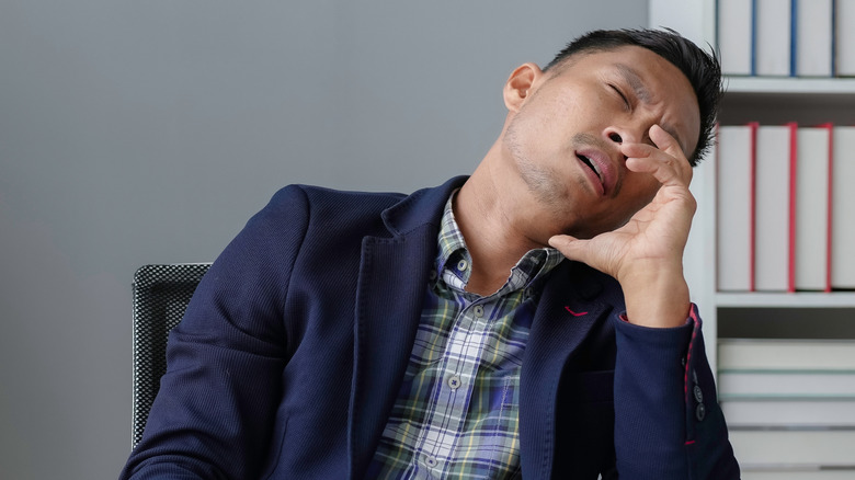 A man falling asleep at his office