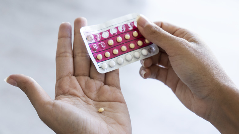 woman's hand holding a pack of birth control pills