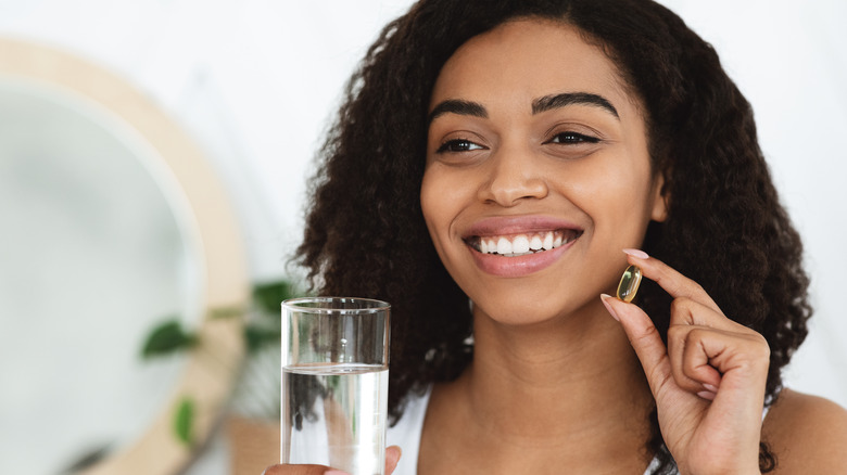 A woman takes a fish oil supplement