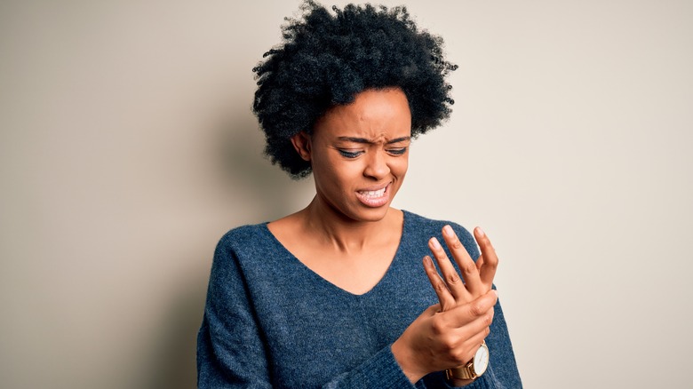 woman holding painful hand with a paper cut