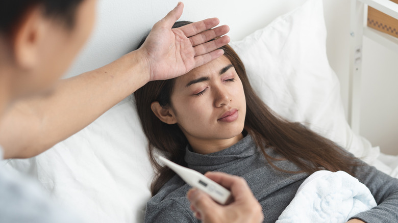 woman lying in bed with a fever