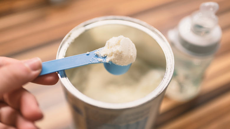 Hand scooping formula out of a canister