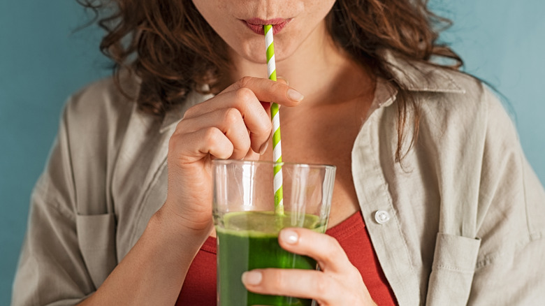 Woman drinking green juice