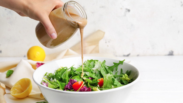 person dressing salad