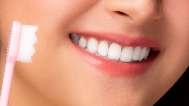 Woman smiling and holding a toothbrush