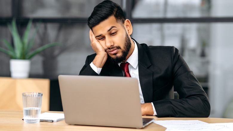 Fatigued man looking at his computer