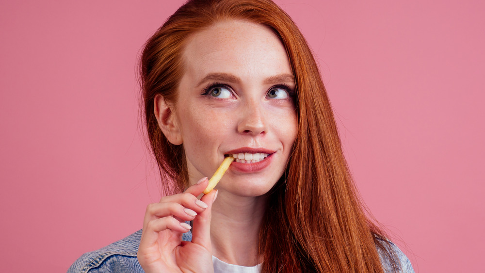Woman eating french fry