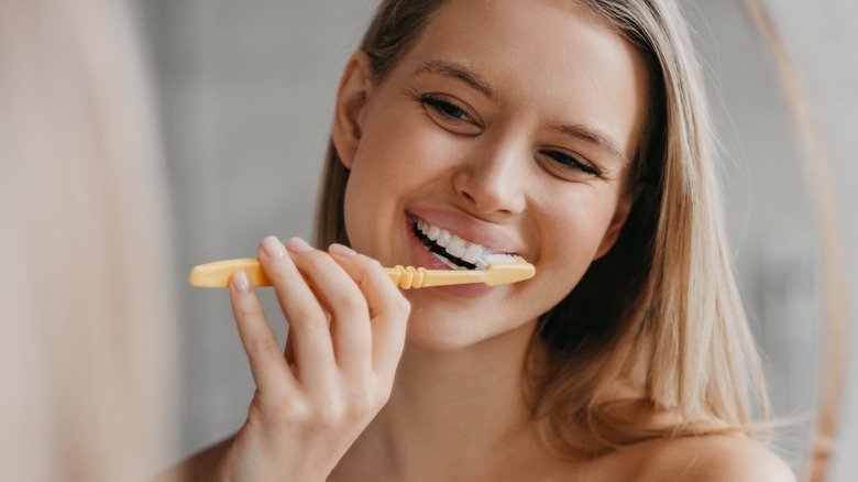 Young woman brushing teeth