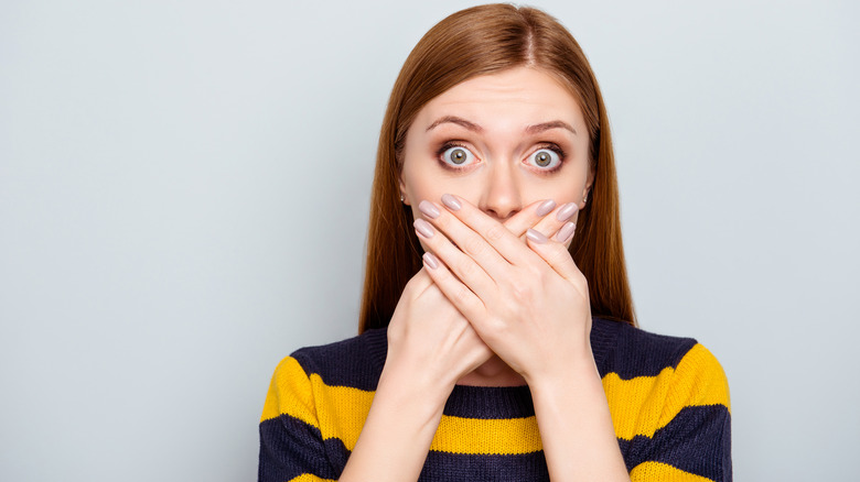 woman covering her mouth and bad breath