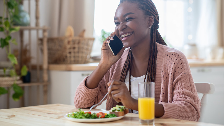 A woman with braces eats a salad