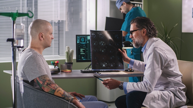 A doctor shows a patient a CT scan