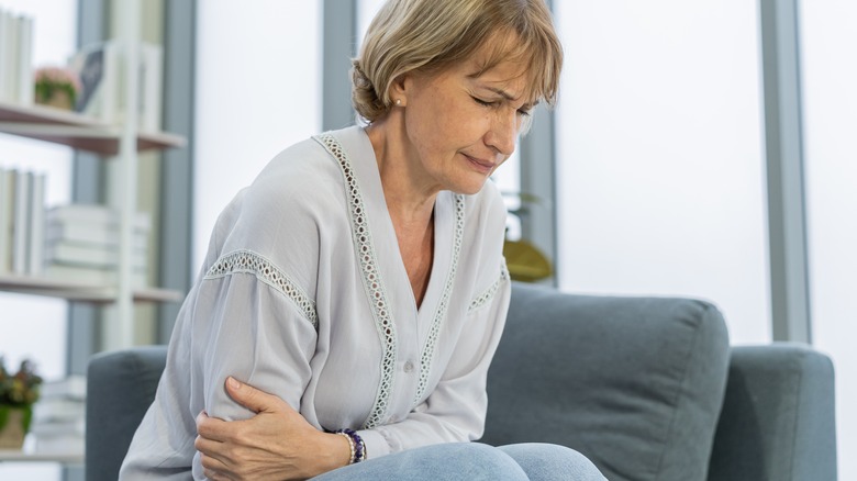 Woman holding her stomach with gas pains