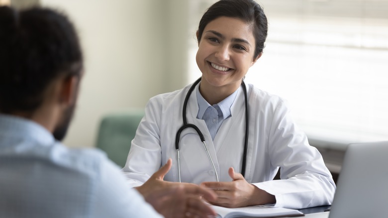Young man talking to smiling doctor