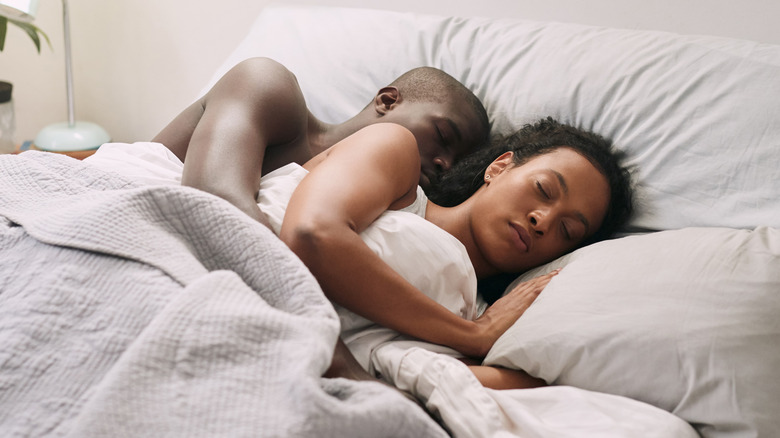 young couple asleep in bed
