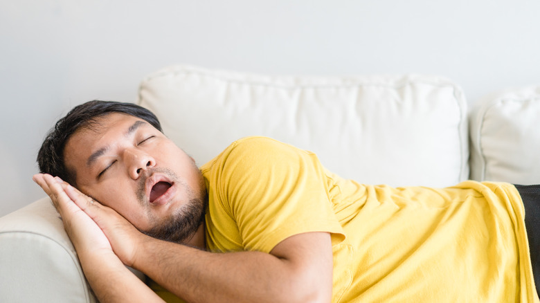 a man snoring on the couch 