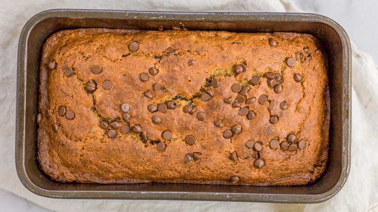 Overhead shot of a loaf of gluten-free chocolate chip banana bread in a baking pan