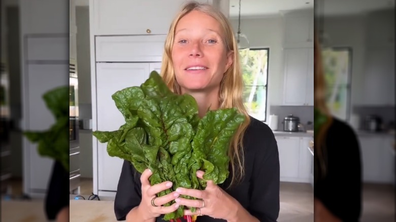 Gwyneth Paltrow holding a bundle of greens