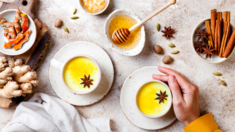 golden milk surrounded by honey and spices