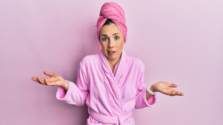 woman in bathrobe shrugging