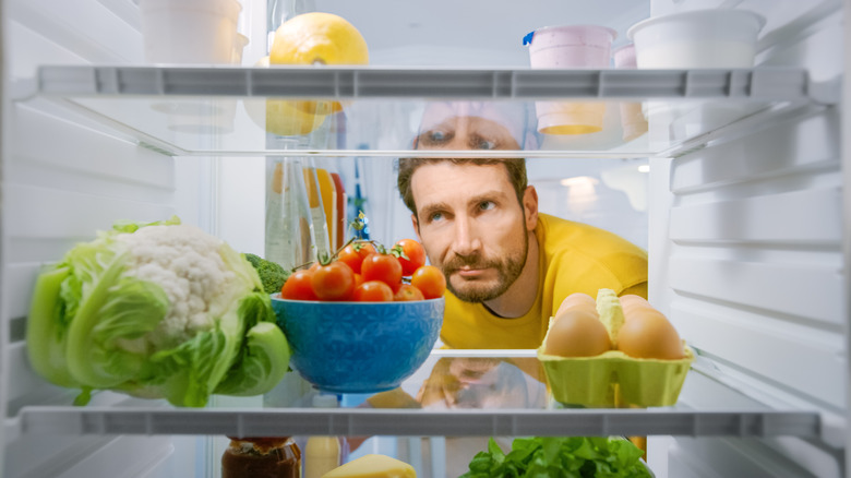 Man looking for snack in fridge