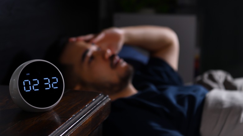 Man in bed with clock