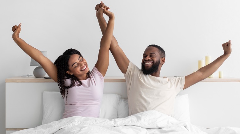 Smiling couple waking up in bed