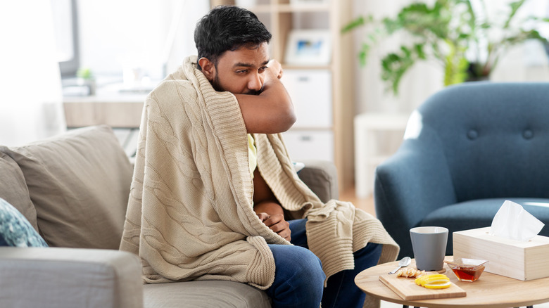 Man coughing into arm