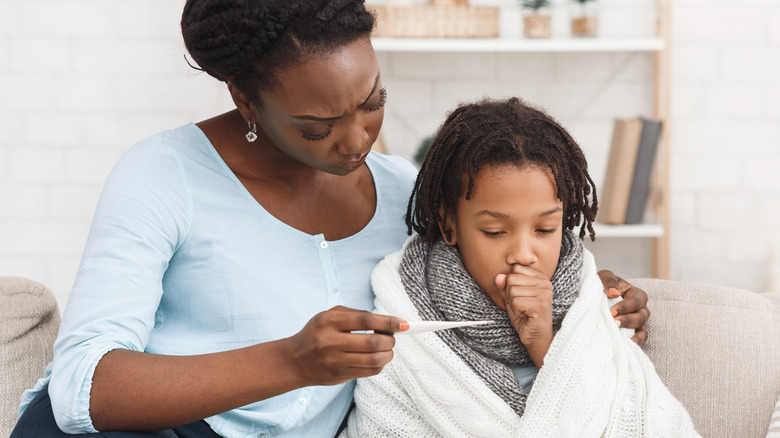 Mother holding child with fever