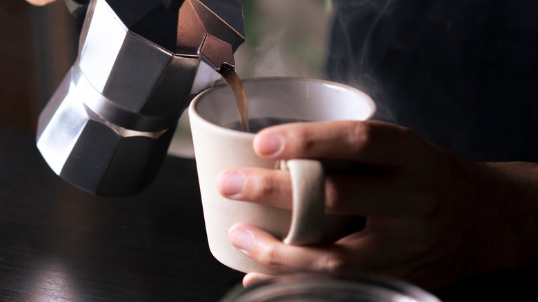 person pouring coffee into cup