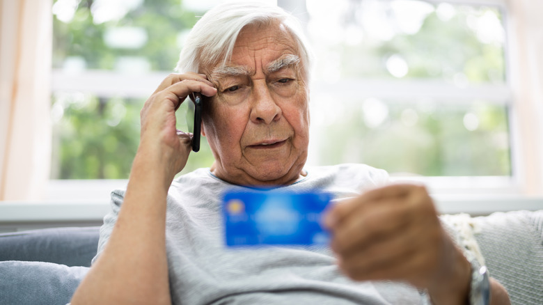 elderly man holding credit card