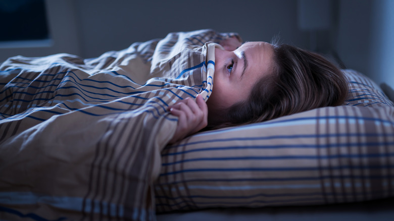 Scared woman laying in bed